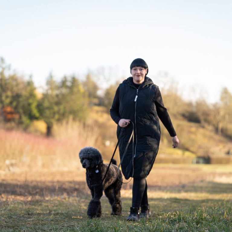 Hundeschule Tanja Kaiser Bild Trainerin läuft mit Ihrem Hund Bei Fuß an der Leine auf einer Wiese